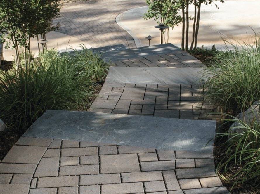 Stone paver walkway through a landscaped yard